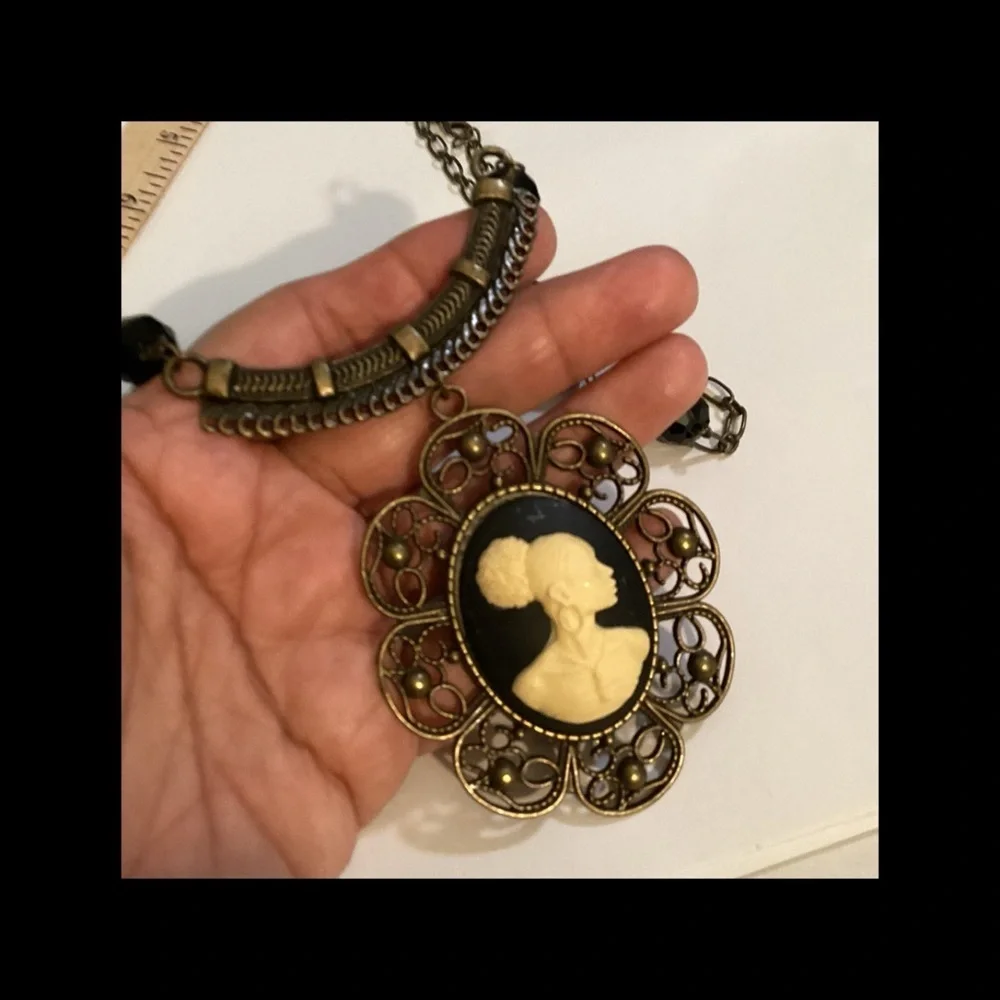 Black and cream vintage necklace on a bronze chain.